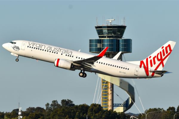 Virgin Australia airplane taking off near control tower, representing travel and airline baggage policy.